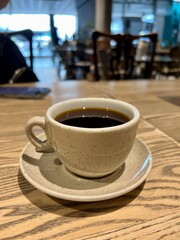 cup of coffee on wooden table in a cafe 