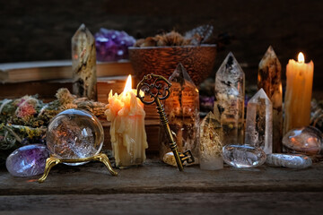 Candles, crystal ball, key, gemstones, magic things on dark wooden background. minerals for Witchcraft, healing Esoteric crystal Ritual. relax, life balance, wiccan, modern magic concept - obrazy, fototapety, plakaty