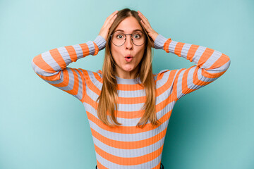 Young caucasian woman isolated on blue background being shocked, she has remembered important...