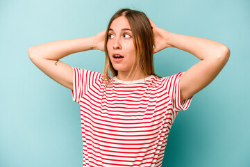 Young caucasian woman isolated on blue background screaming, very excited, passionate, satisfied with something.