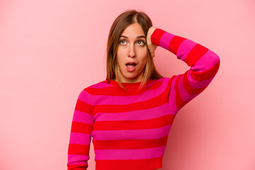 Young caucasian woman isolated on pink background being shocked, she has remembered important meeting.