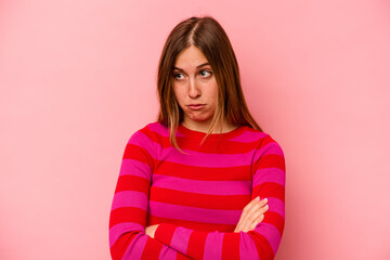 Young caucasian woman isolated on pink background tired of a repetitive task.