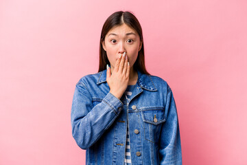 Young Chinese woman isolated on pink background shocked, covering mouth with hands, anxious to discover something new.