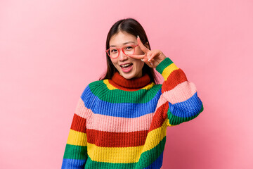Young Chinese woman isolated on pink background dancing and having fun.