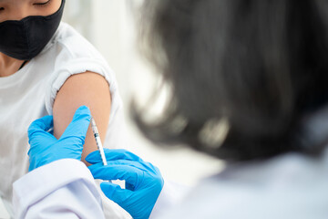 Doctor holding syringe for prepare vaccinated in the shoulder of Asian boy kids in the hospital....