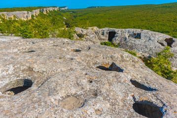 Ancient stone caves in a town-fortess Eski-Kermen high in a rocky mountains, Crimea.