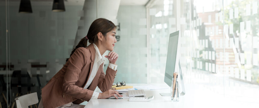 Side view of business asian woman or accountant working computer at office