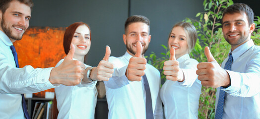 Successful business people with thumbs up and smiling.