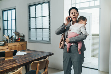asian female ceo carrying toddler just getting home is receiving emergent phone call from company....
