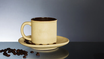 Coffee cup and saucer on old glass table. Dark background.