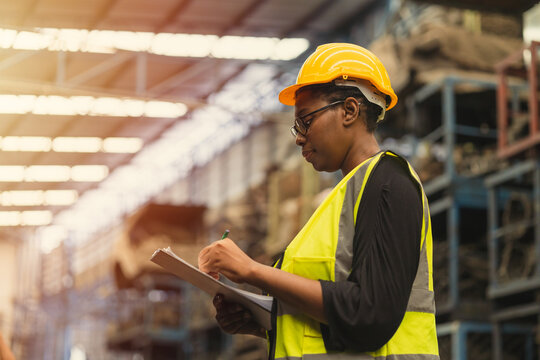 Engineer black women worker, Professional woman afican mechanical maintenance work in factory checking stock inventory in warehouse.