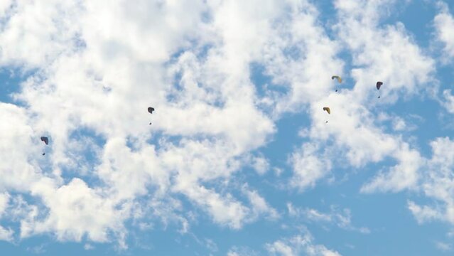 Parachutes in front of the clouds at Manali in Himachal Pradesh, India. Tourists enjoying paragliding experience at Manali. People enjoying the paragliding experience at Manali	