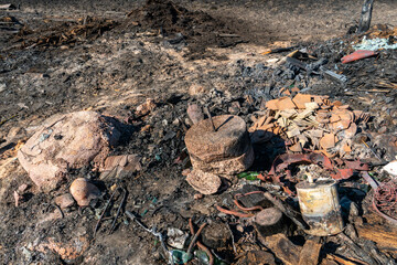 The consequences of a fire in an old wooden country house. Ashes and burnt boards close-up. A fire in a residential wooden house due to arson of dry grass.