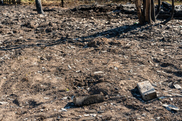 The consequences of a fire in an old wooden country house. Ashes and burnt boards close-up. A fire in a residential wooden house due to arson of dry grass.