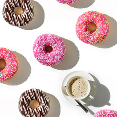 A cup of coffee and a variety of donuts on a white background. Flat lay composition with coffee and...