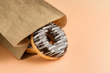 paper bag with chocolate donuts close-up.