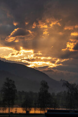 beautiful sunrise with a golden sky, clouds and mountain silhouette