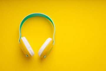 Colorful wireless headphones isolated on yellow background