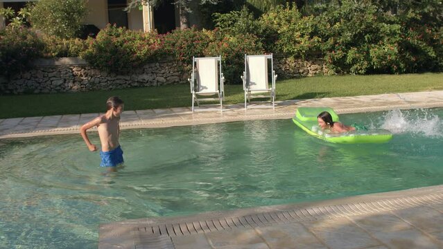 Child uses green inflatable mattress while swimming in a outdoor pool without adults. Precautions on the water. The boys spend their holidays with health benefits. IT, Borgagne, 6.10.2021 