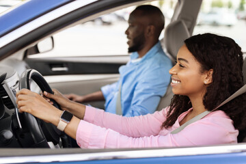 Happy black couple enjoying long drive on a car