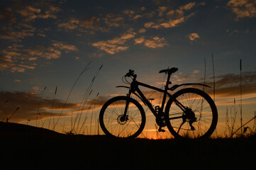 Obraz premium Eine Mountainbike Fahrrad Silhouette im Sonnenuntergang.