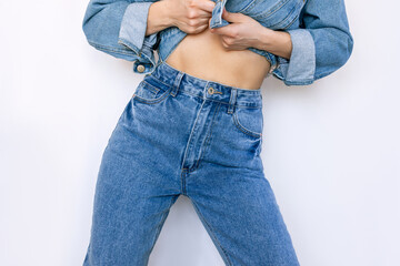 Cropped shot of young slender woman in a fashionable blue jeans with a high fit isolated on a white background. Beauty and fashion concept - Powered by Adobe