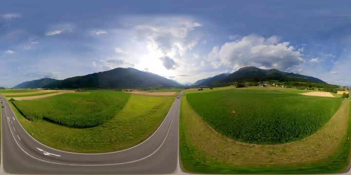 360 Aerial of Mountain road near wheat and a corn field
