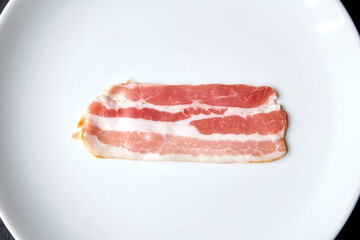 Bacon strip, raw smoked pork meat slice isolated on white