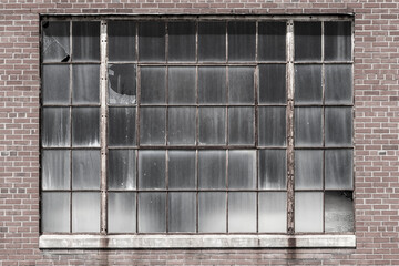 Broken windows and worn exterior of an abandoned coal power plant. Coal power plants are being...