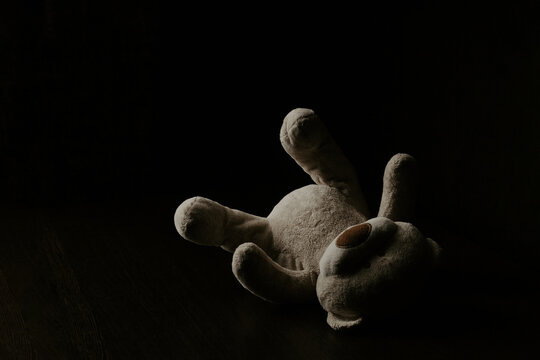 Teddy bear laying down alone at night. Lonely concept, international missing children's day