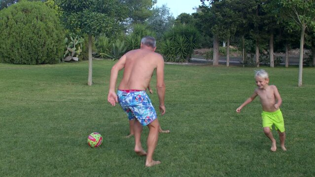Active family lifestyle. A man with children plays ball on the lawn during the summer holidays. A fun active pastime. IT, Borgagne, 8.10.2021 