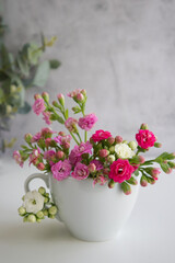 Obraz na płótnie Canvas white cup with spring flowers instead of coffee
