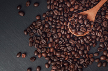 spoon with coffee on a black background.  spoon with coffee beans. coffee bean. Texture  of roasted coffee beans .