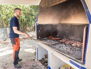 Young man making and enjoying a barbecue.