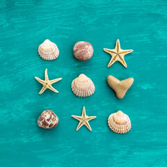 Flat lay seashells, small stones and dry starfish on aquamarine background