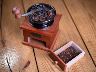 Old vintage grinder with roasted coffee beans and grind coffee