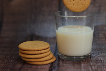 Vaso de leche con galleta cayendo