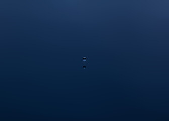 Splash and a ball of water on a blue background. Reflection on the surface of the water.