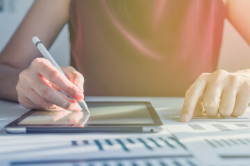 Technology Business Concept: A Woman is taking notes on a tablet with a digital pencil.