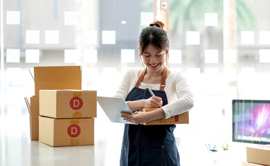 Portrait of Starting small businesses SME owners female entrepreneurs working on receipt box and check online orders to prepare to pack the boxes, sell to customers, sme business ideas online.