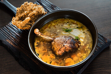 soup with duck on wooden board