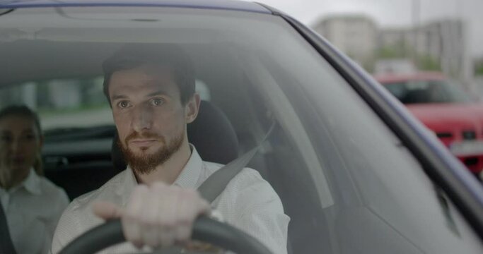 Young taxi driver with a beard is driving on the green light