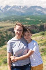 A child embraces mom in the mountain trip. Domestic tourism, travel, lesure and freedom. Altai mountain, beauty summer evening landcape