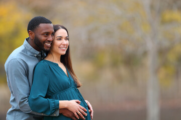 Obraz premium Interracial couple with pregnant wife looking away