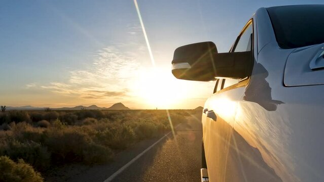 Driving east as the sun sets in the west in the Mojave Desert's barren wasteland