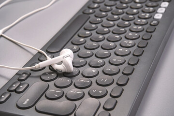 Podcast concept. Black microphone recorder, content notebook keypad with white earphones. Close up. Audio music device. Recording production. School knowledge equipment. Home online teaching. Grey