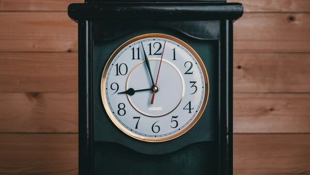Vintage Clock Arrows Rotate at 9 PM or AM, Full Turn of Time Hands, Timelapse. Old Retro wall clock with second, minute, and hour hands on a white circular dial. An antique clock on wooden background