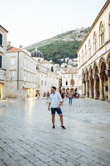 Fototapeta na wymiar Handsome sexy man in white shirt in old european city. Summer in Croatia. Dubrovnik city