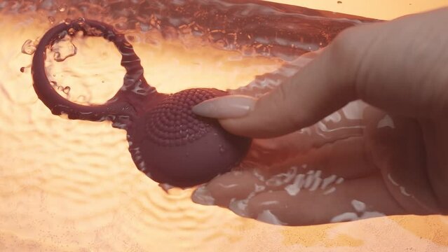 Close up of new modern sex toy vibrating underwater in female hand. Creative. Concept of masturbation and sex life.