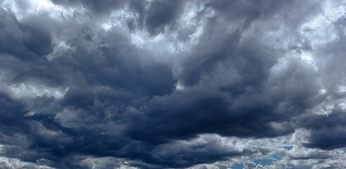 Obraz premium The dark sky with heavy clouds converging and a violent storm before the rain.Bad or moody weather sky and environment. carbon dioxide emissions, greenhouse effect, global warming, climate change.